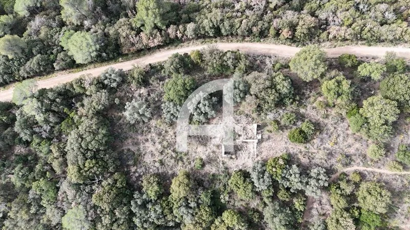 Terreno montañoso con masía en ruinas