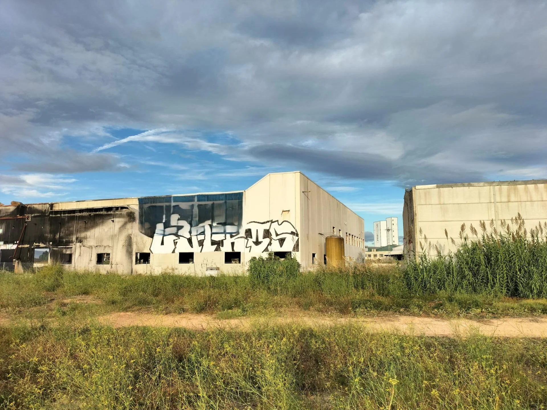 Industrial plot with fire-damaged warehouse