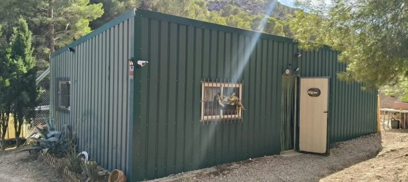 Fenced plot with prefabricated house