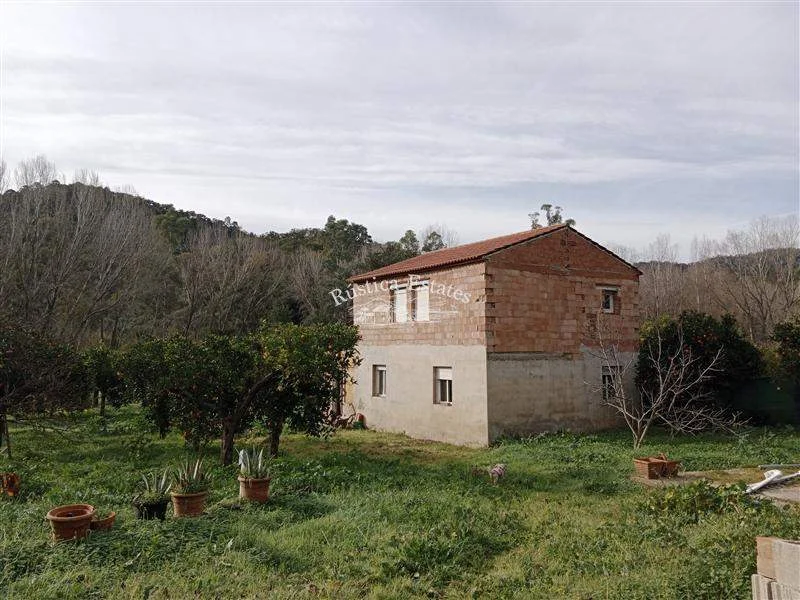 Finca junto al río con casa sin terminar